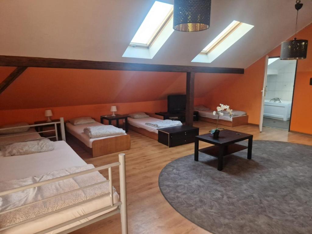 a room with two beds and a room with skylights at Apartament Pracowniczy in Pogórze
