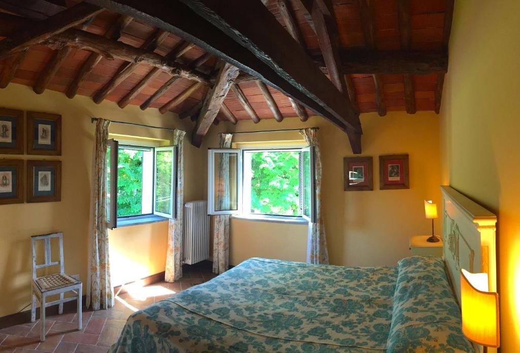 a bedroom with a bed and two windows at TENUTA MONTEGRANDE 1893 in San Salvatore Monferrato