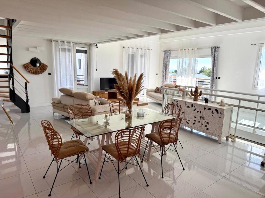 a living room with a table and chairs at Villa Pasithéa in Sainte-Suzanne