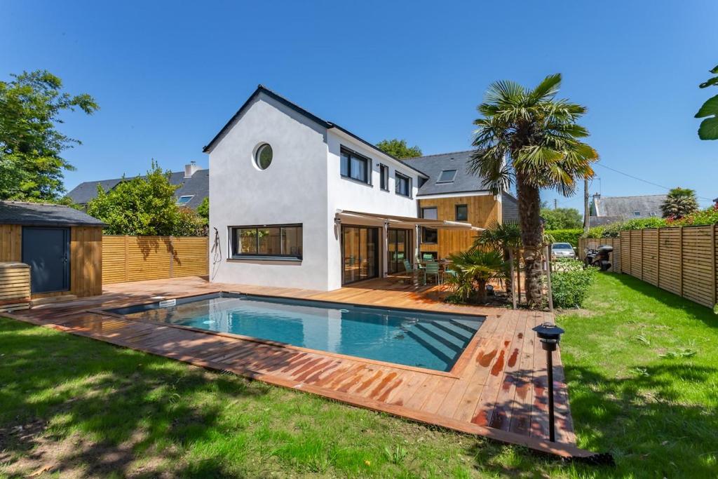 une maison avec une piscine dans une cour dans l'établissement Une parenthèse enchantée à Larmor-Baden, à Larmor-Baden