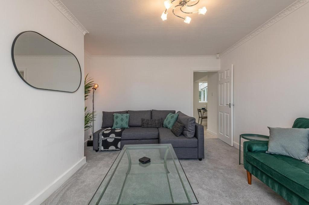a living room with a couch and a mirror at Spacious 5 Bed Close to Elland Road, First Direct Arena & Headingley Stadium in Roundhay