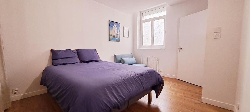 - une chambre avec un lit doté de draps violets et d'une chaise dans l'établissement Appartement calme, hypercentre, au pied du marché, à Rochefort