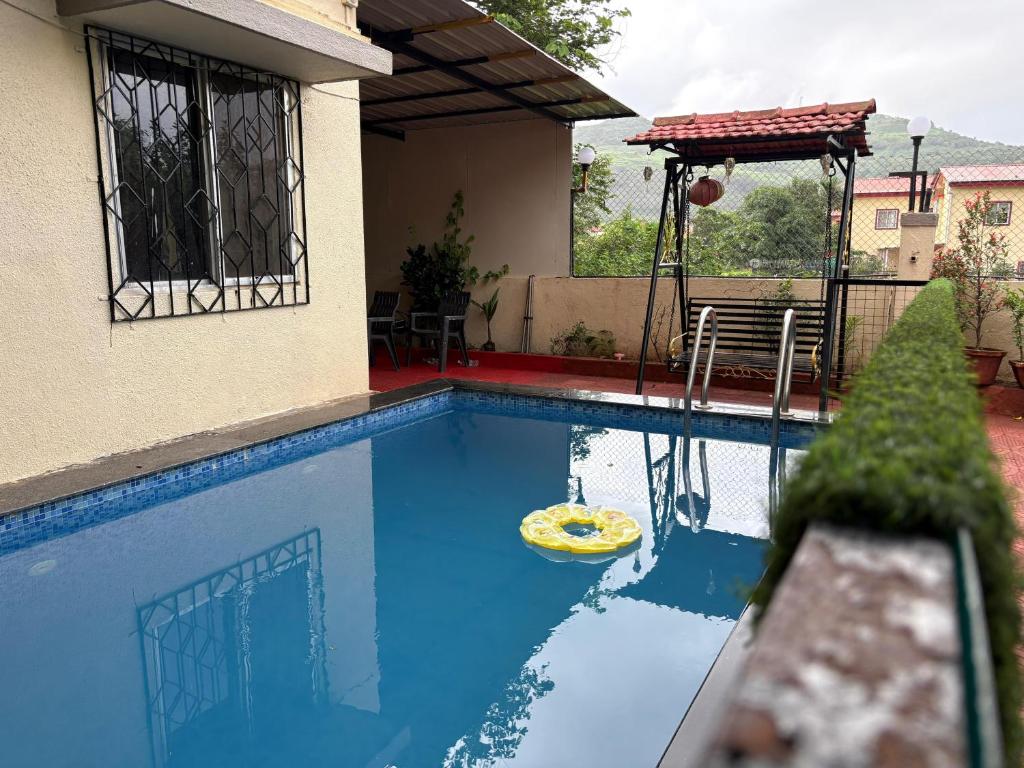 una piscina con frisbee giallo di Capricorn villa a Lonavala