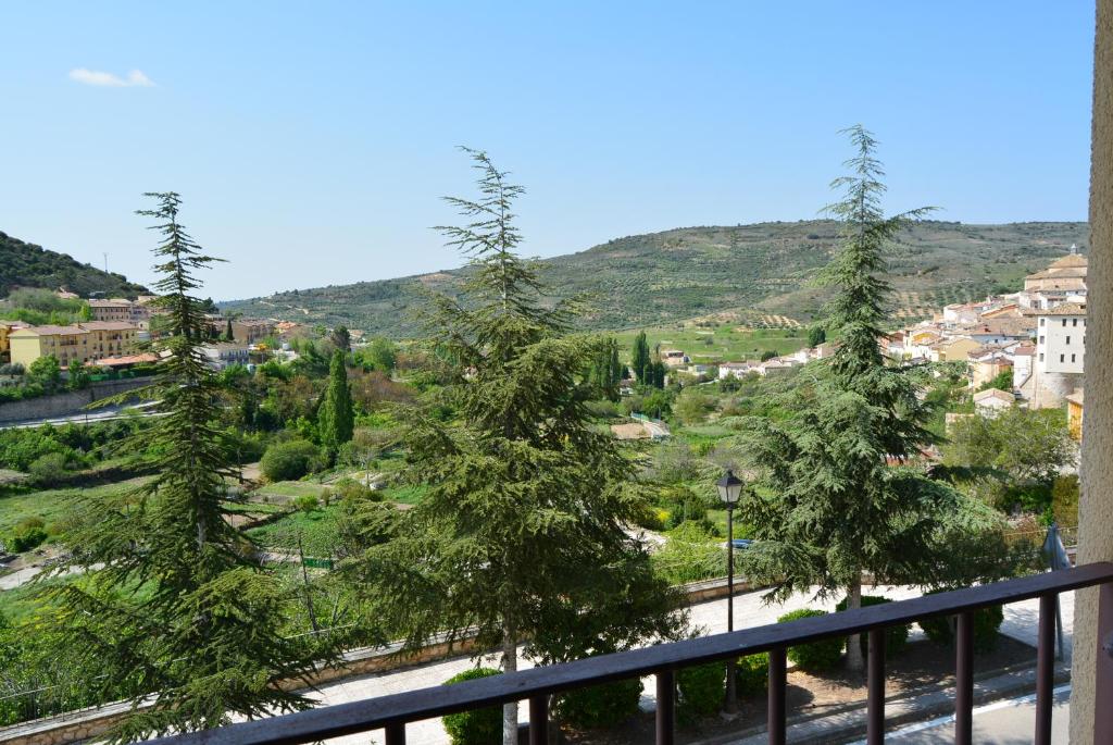 uma vista para a cidade a partir de uma varanda com árvores em Hotel Mayno em Pastrana
