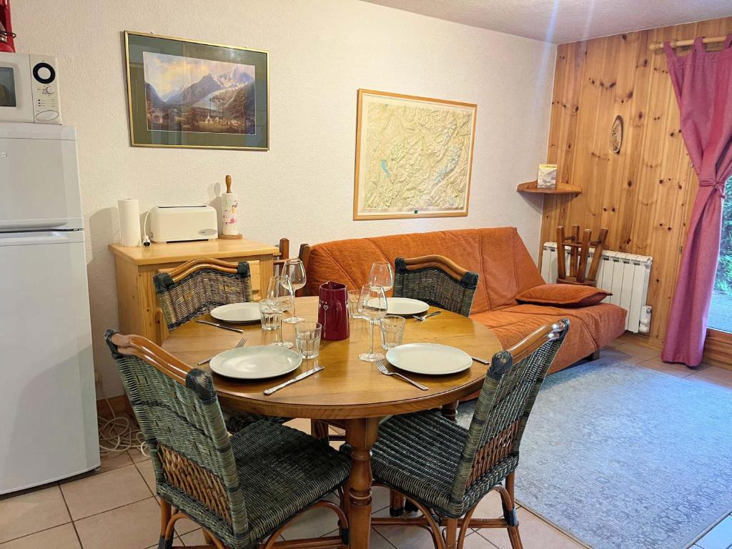 un salon avec une table avec des chaises et un canapé dans l'établissement Appartement T2 cosy avec jardinet, proche centre et skibus, WiFi, parking et équipements complets - FR-1-624-61, à Samoëns