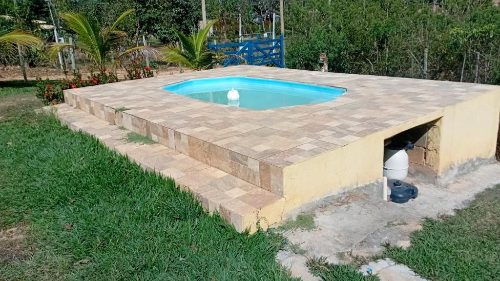 ein Pool mit einer Steinmauer um ihn herum in der Unterkunft Camping dos oliveira in Jaboticatubas