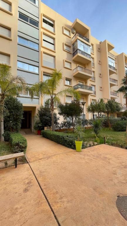 a large apartment building with a bench in front of it at Appartement moderne équipé, situé au centre de Oujda in Oujda