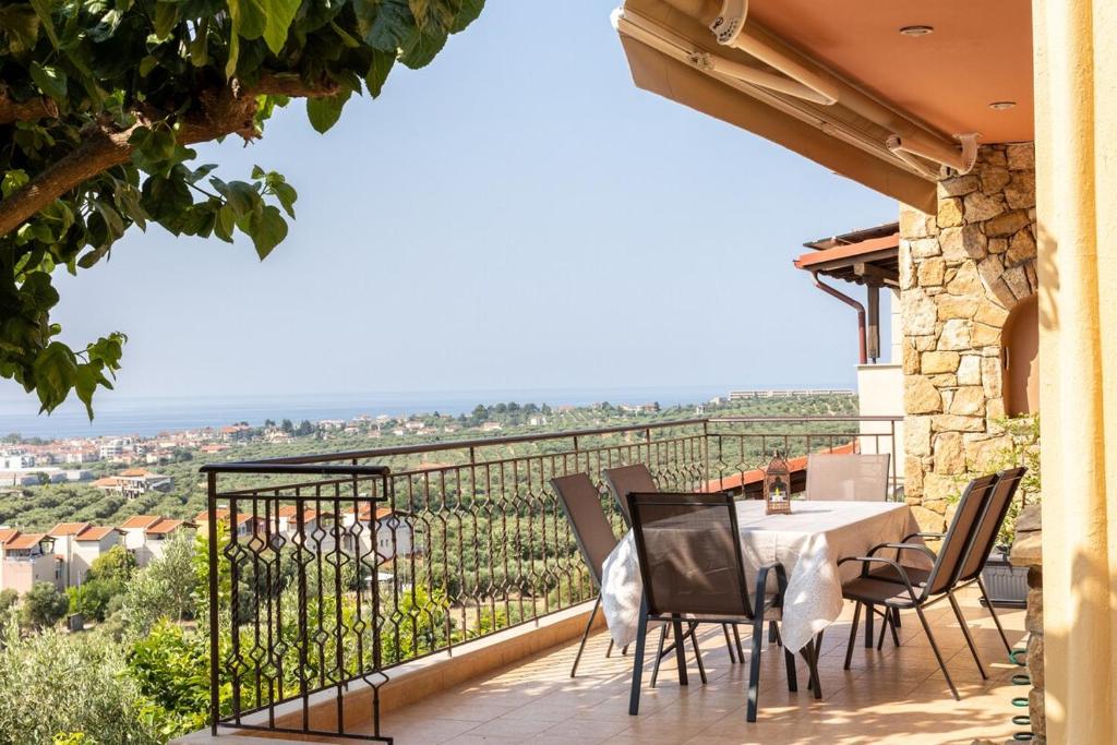ネア・ムダニアにあるThe Grand Panorama Villaのバルコニーにテーブルと椅子が置かれたパティオ