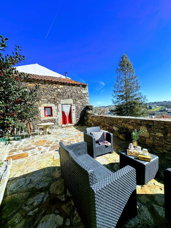 a patio with chairs and a table and a building at Sweet Côa in Sabugal