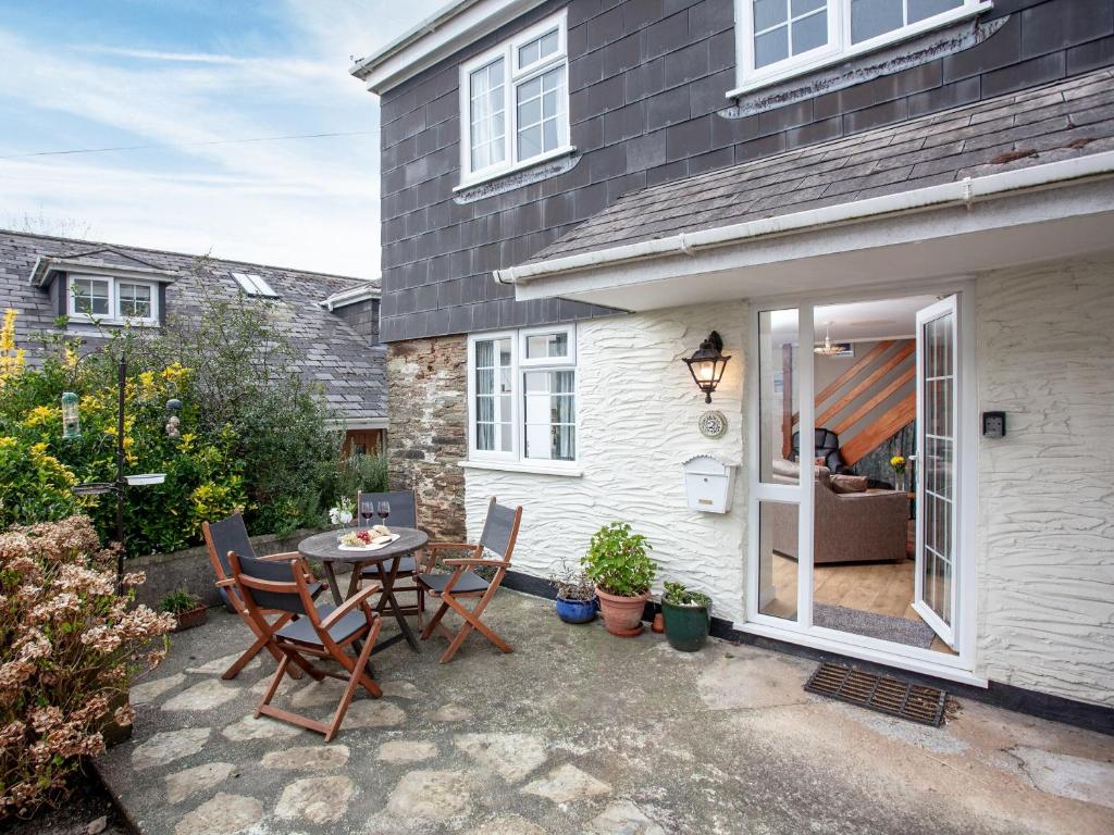 a patio with a table and chairs in front of a house at Garden Cottage in Kingsbridge