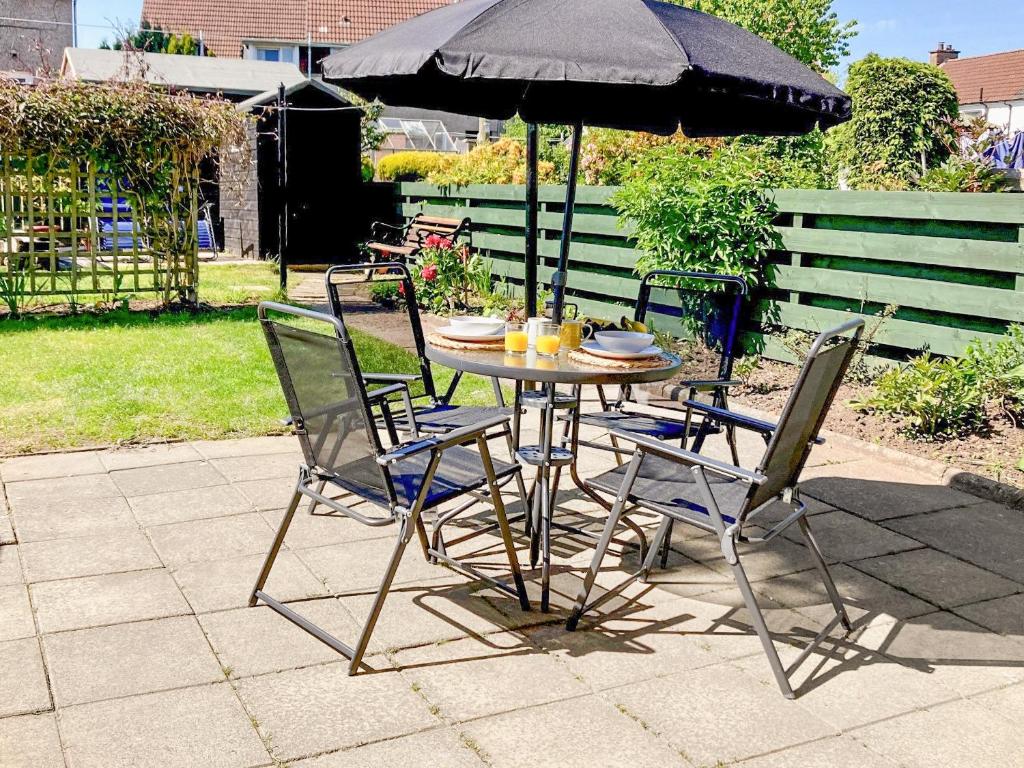 a table with chairs and an umbrella on a patio at Castle Park in Ceres
