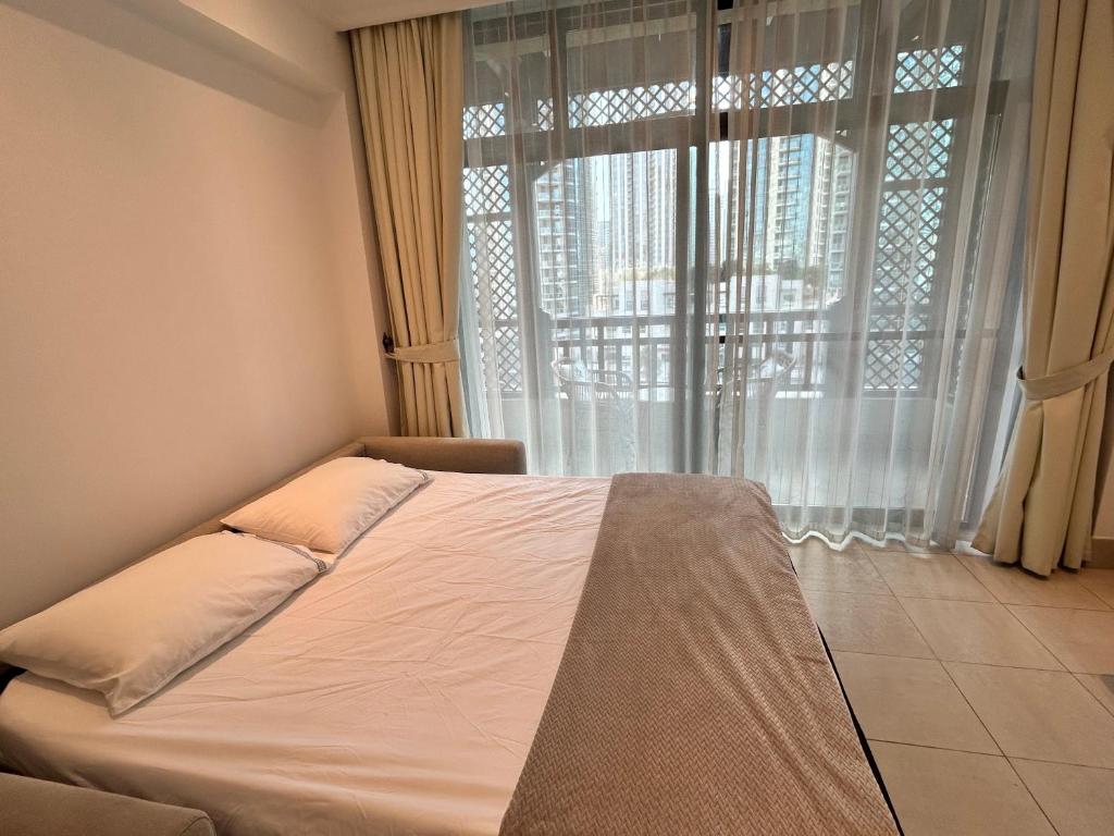 a bed in a room with a large window at Dubai mall Aparment in Dubai