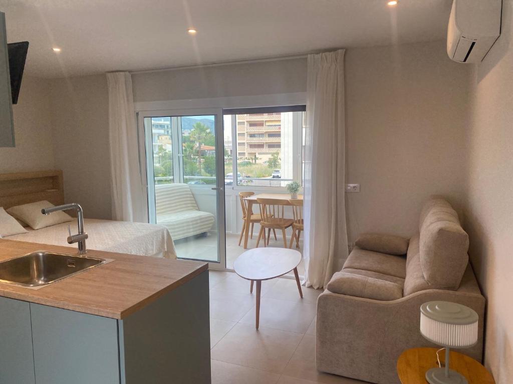 una cucina e un soggiorno con un divano e un tavolo di Miramar 14A a Roses