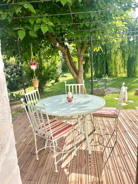 une table et deux chaises sur une terrasse en bois dans l'établissement Appartement cosy, à Saint-Hilaire-de-Brethmas
