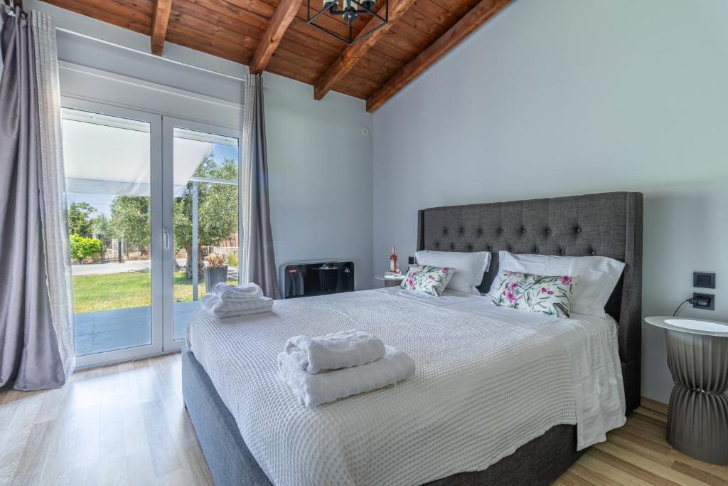 une chambre avec un grand lit avec des draps blancs dans l'établissement Villa Olive & Stone Loutraki, à Loutraki
