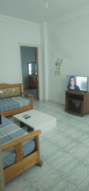 Habitación con 2 camas y TV. en une chambre, un salon, cuisine et balcon, en Monastir