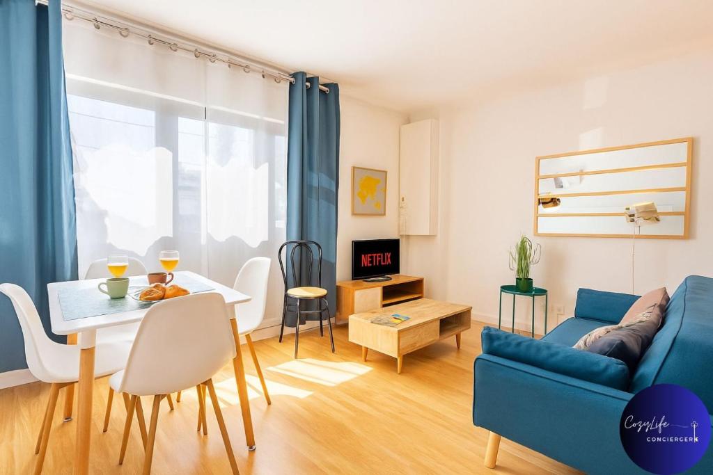 a living room with a blue couch and a table at La Chrysalide by CozyLife - Centre Ville in Niort