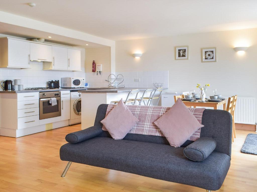 a living room with a couch and a kitchen at Sovereign House in Milford Haven