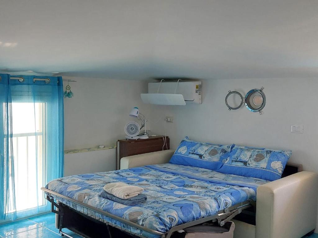 a bedroom with a bed with a blue comforter at Casa Blu with Sea View - Borgo Stays in Sperlonga