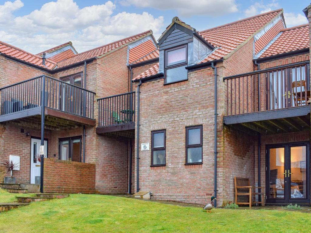 ein Backsteinhaus mit Balkon und Hof in der Unterkunft Ammonite Cottage in Whitby