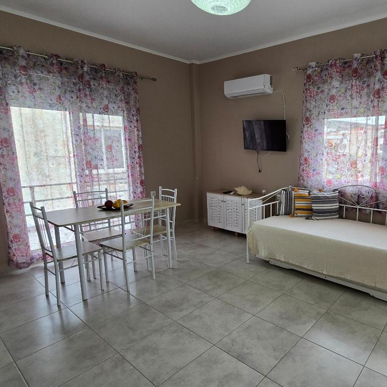 a living room with a table and a bed and a bedroom at Vasilikis Place in Elafonisos