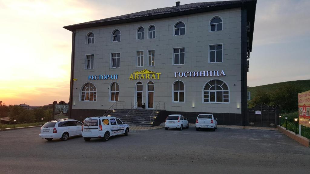 un edificio con coches estacionados en un estacionamiento en Hotel Ararat, en Lermontov
