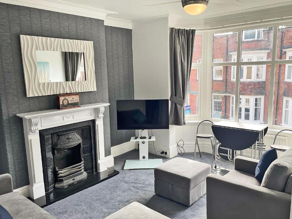 a living room with a fireplace and a tv at Rutland Retreat in Filey