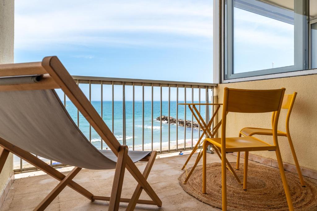 Cette chambre comprend une chaise et offre une vue sur l'océan. dans l'établissement 1ère ligne avenue saint maurice avec vue mer, à Palavas-les-Flots
