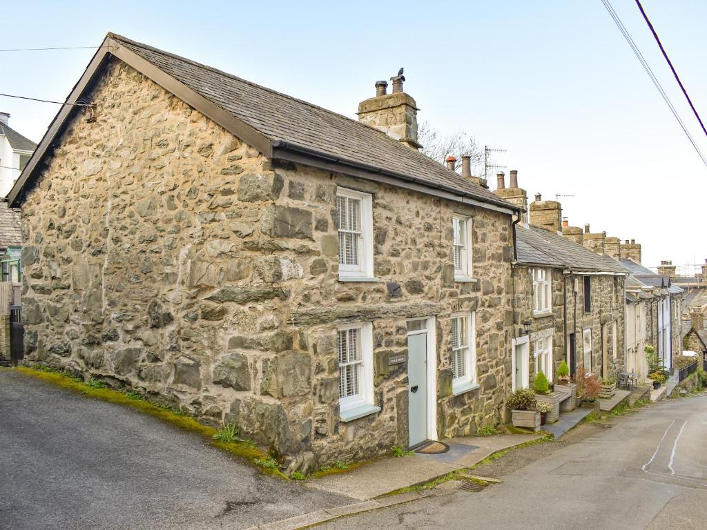 an old stone house on the side of a street at Tryfar House in Harlech