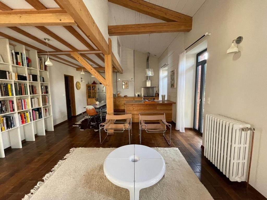 un salon avec une table et des chaises blanches dans l'établissement La maison vigne, à Crest