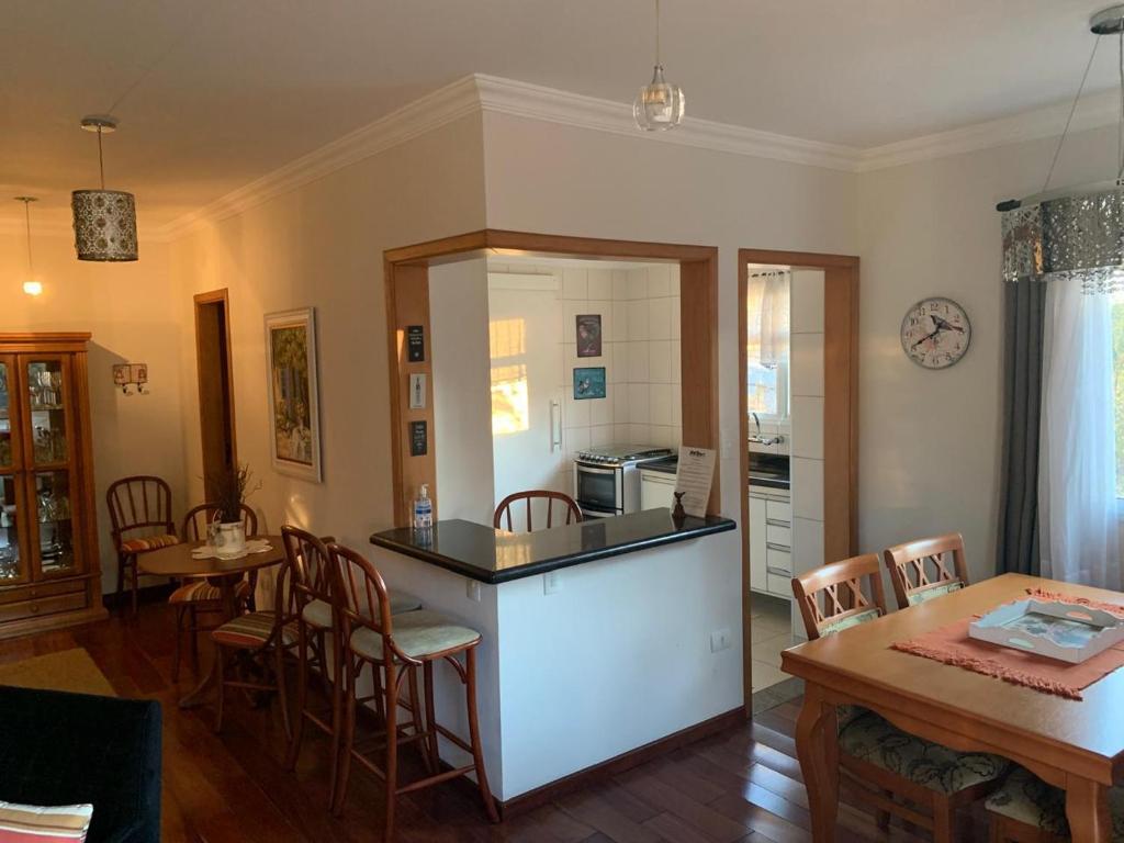a kitchen and dining room with a table and chairs at Dúplex a 800m do centro do capivari in Campos do Jordão
