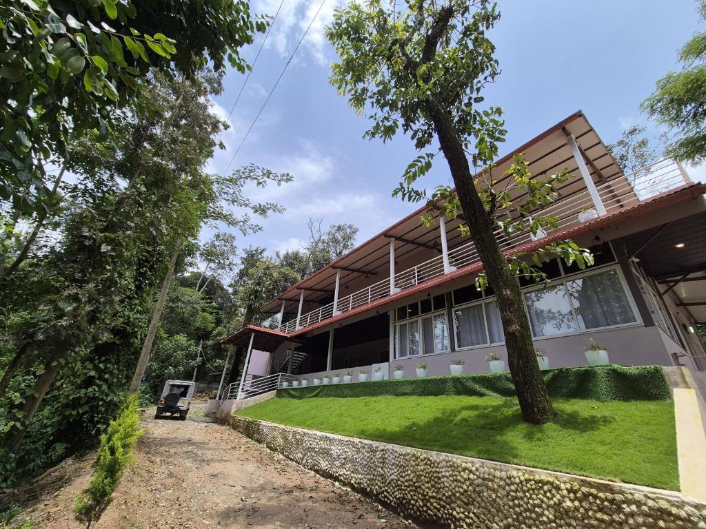 a house with a tree in front of it at Tropica Retreat by Dazzle Destinations - Private Waterfalls, Private Rooms and Bonfire in Aldūr