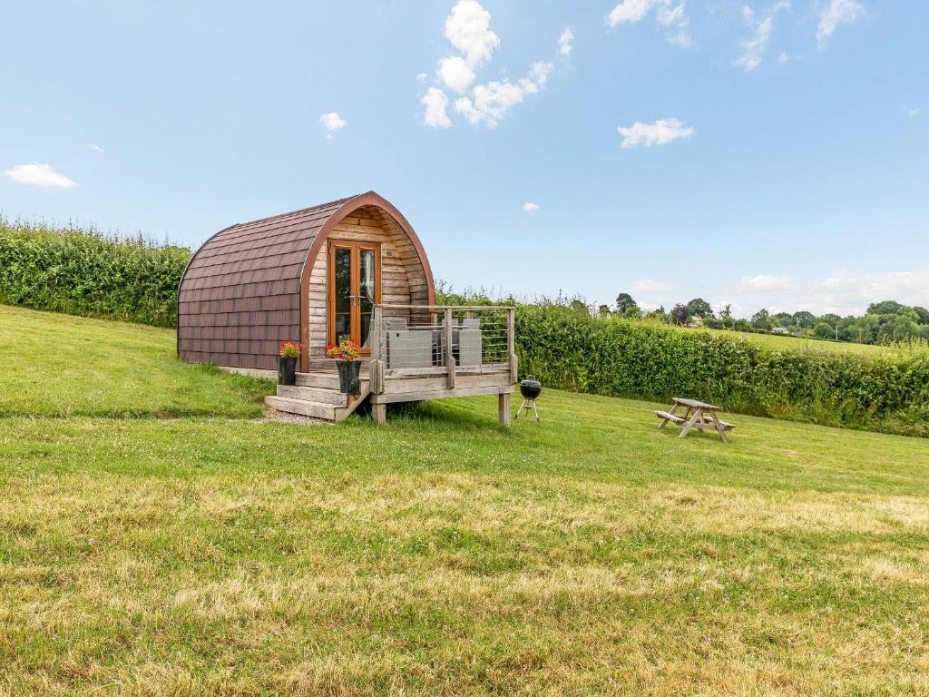 a small dome house in a field with a bench at Pod Two - Uk44403 in Ross on Wye