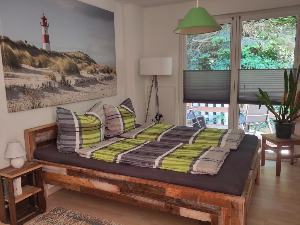 a bedroom with a bed with a green and yellow blanket at Große Kutscherwohnung in Kiel