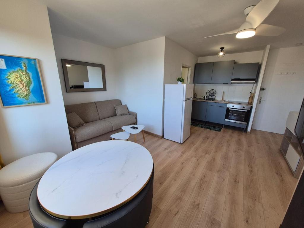 Il comprend un petit salon avec une table et une cuisine. dans l'établissement City center apartment with sea view, à LʼÎle-Rousse