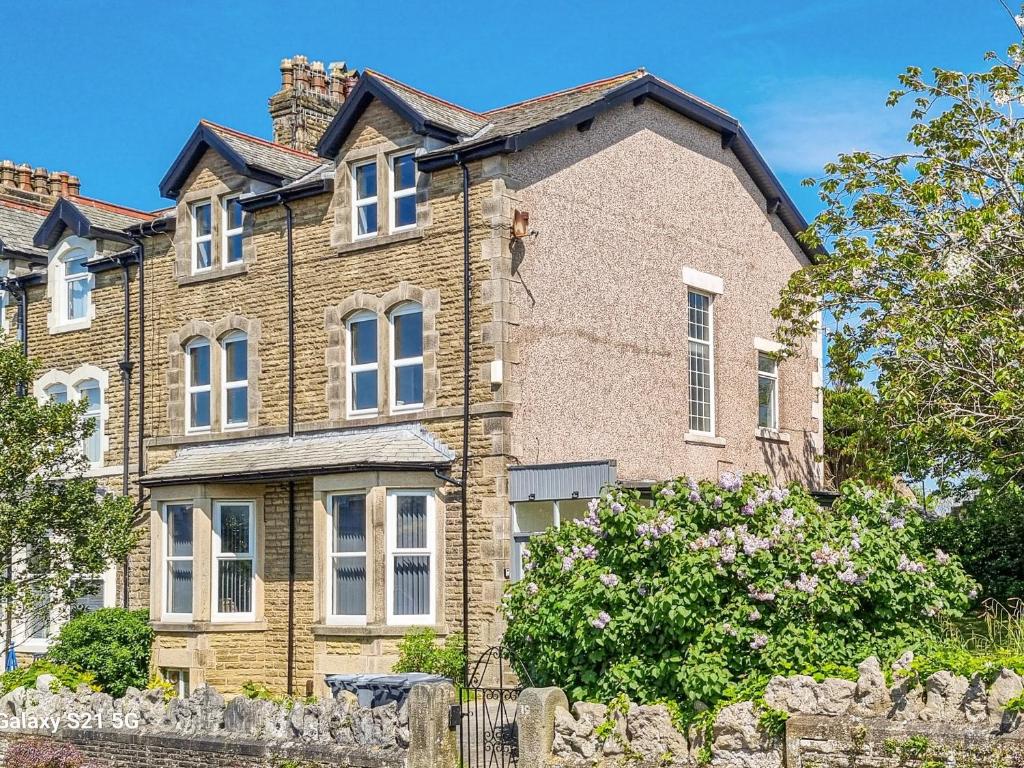 a large brick house with a fence in front of it at Sunnyside Hestbank in Hest Bank
