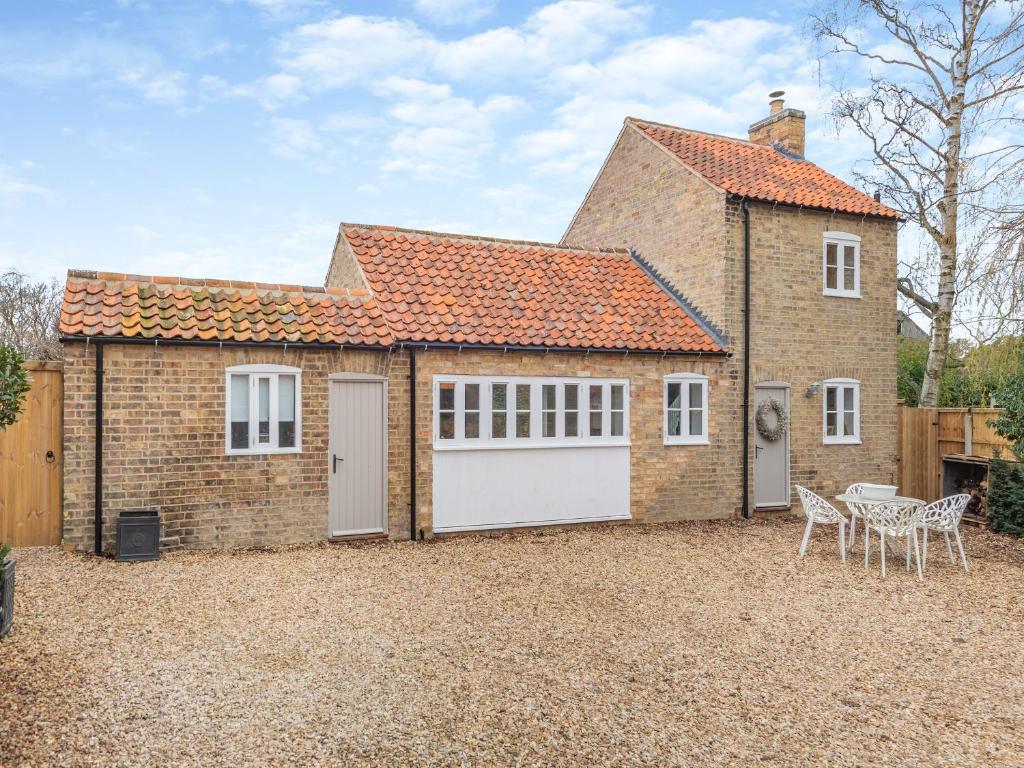 a large brick house with two white garage doors at The Ostlers Cottage in Sleaford