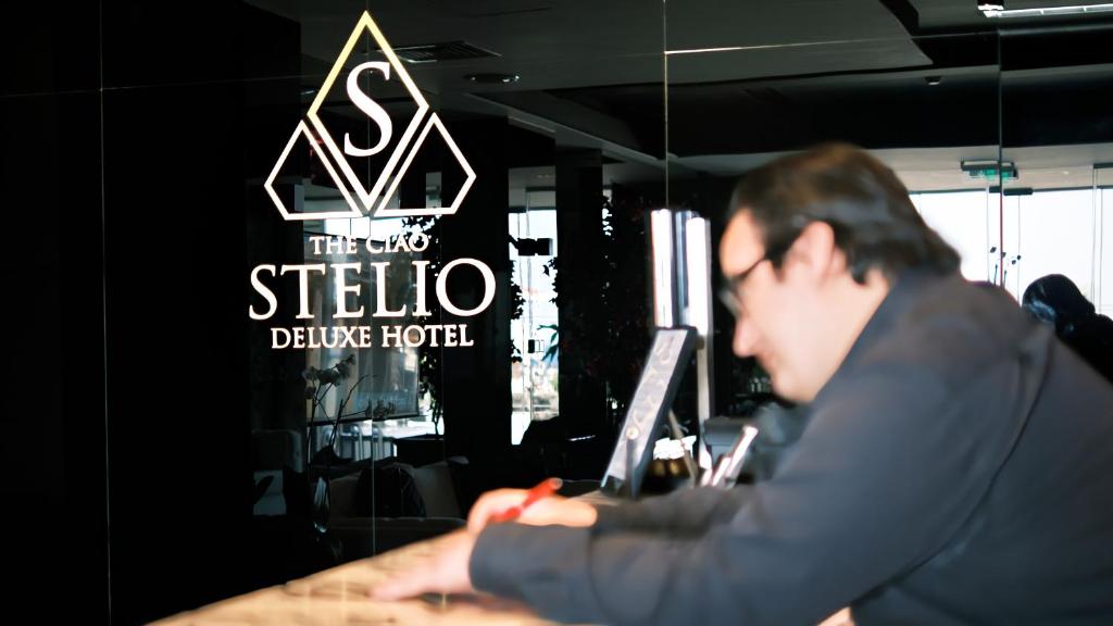 a man sitting at a table working on a laptop at The Ciao Stelio Deluxe Boutique Hotel - Adults Only in Larnaka
