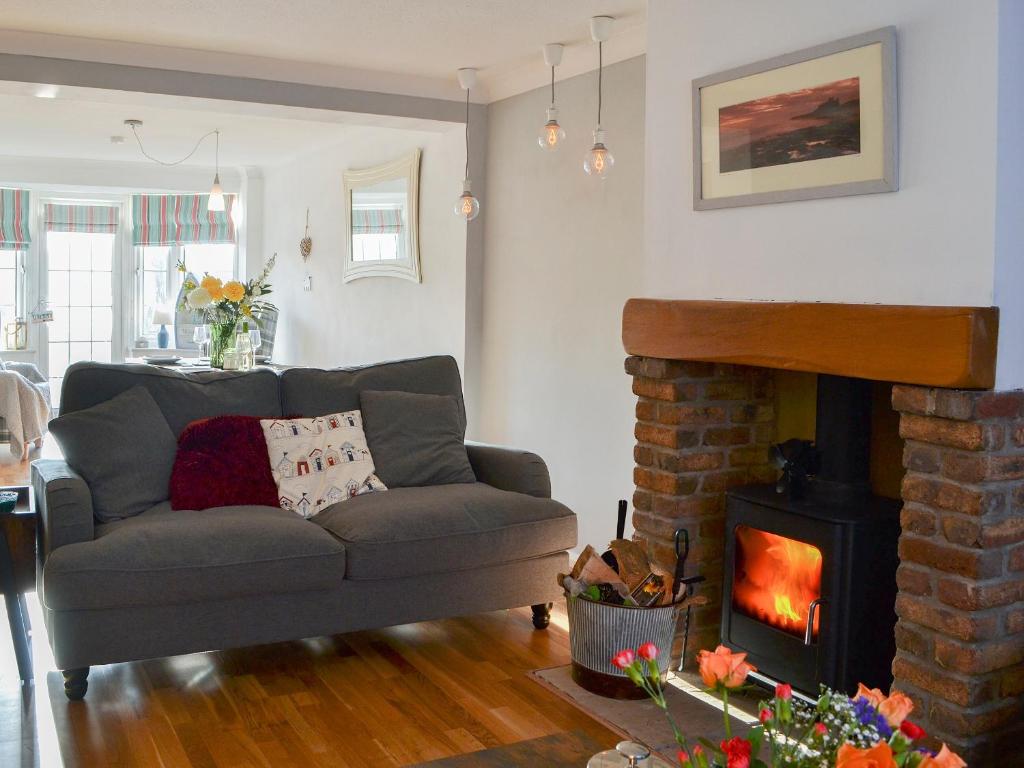 a living room with a couch and a fireplace at April Cottage in Sewerby
