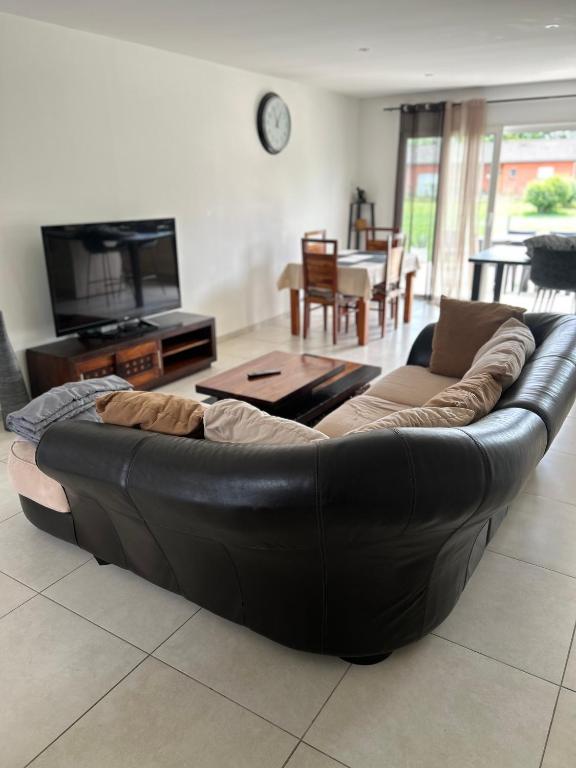 - un canapé en cuir noir dans le salon dans l'établissement David, à La Tour-du-Crieu