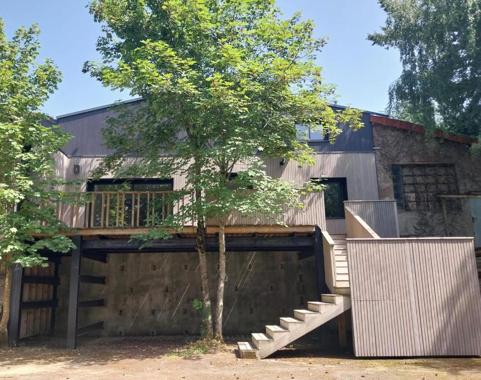 ein Haus mit einer Terrasse und einem Baum in der Unterkunft Maison moderne proche de la gare de Vannes in Saint-Avé