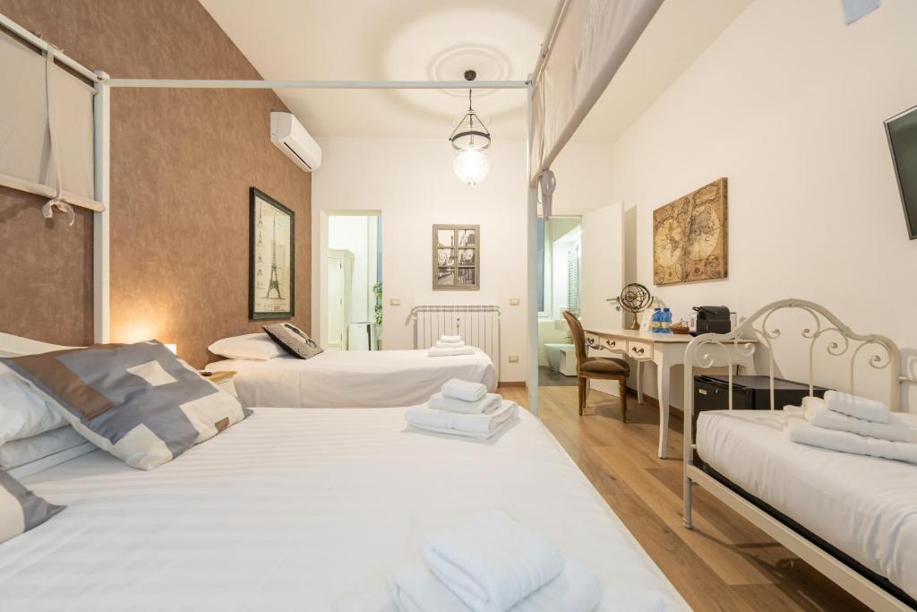 Pokój hotelowy z 2 łóżkami i biurkiem w obiekcie Popolo & Flaminio Rooms w Rzymie