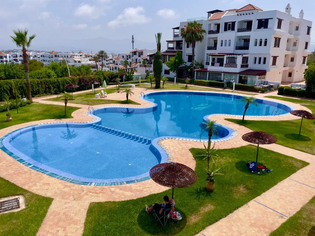 una gran piscina con sombrillas junto a un edificio en Résidence CaboBeach, en Cabo Negro