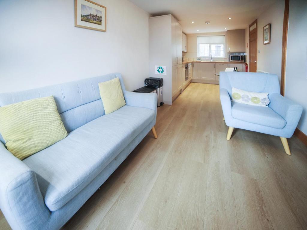 a living room with a blue couch and a chair at Borrowdale View - Uk45176 in Threlkeld