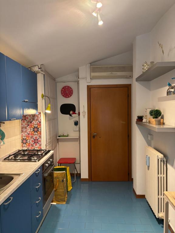 a kitchen with blue cabinets and a brown door at Loggia Rossini in Pesaro