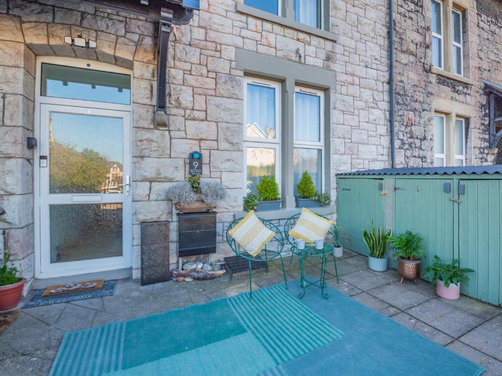 a patio with a table and chairs in front of a building at Rhiw Bank Apartment in Colwyn Bay