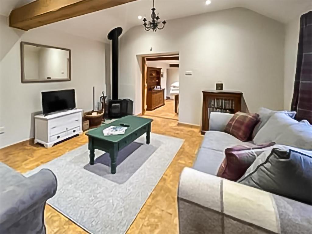 a living room with a couch and a table at Byre Cottage in Billingshurst