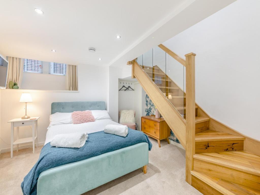 a bedroom with a bed and a stair case at Town Square Apartment - Uk45611 in Alnwick