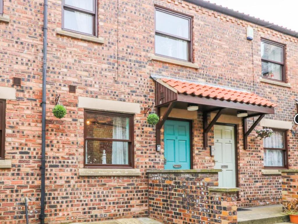 a brick house with a blue door at Whitby Sands in Whitby