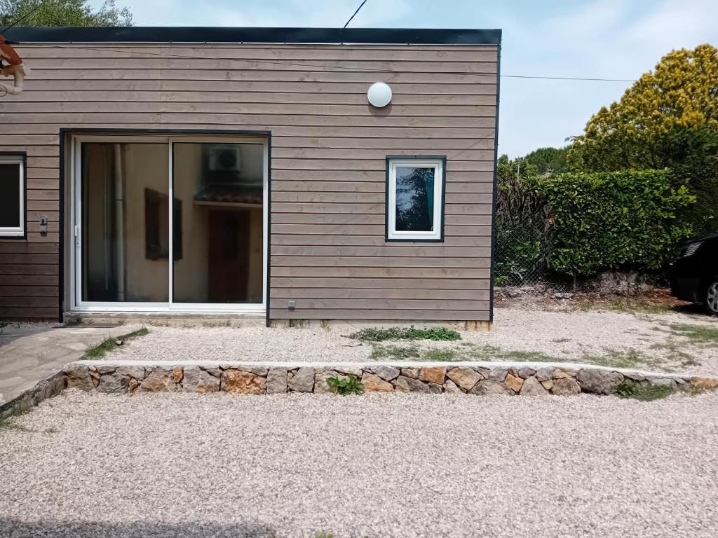 une maison avec une fenêtre et une allée en pierre dans l'établissement Appartement avec piscine au calme, à Grasse